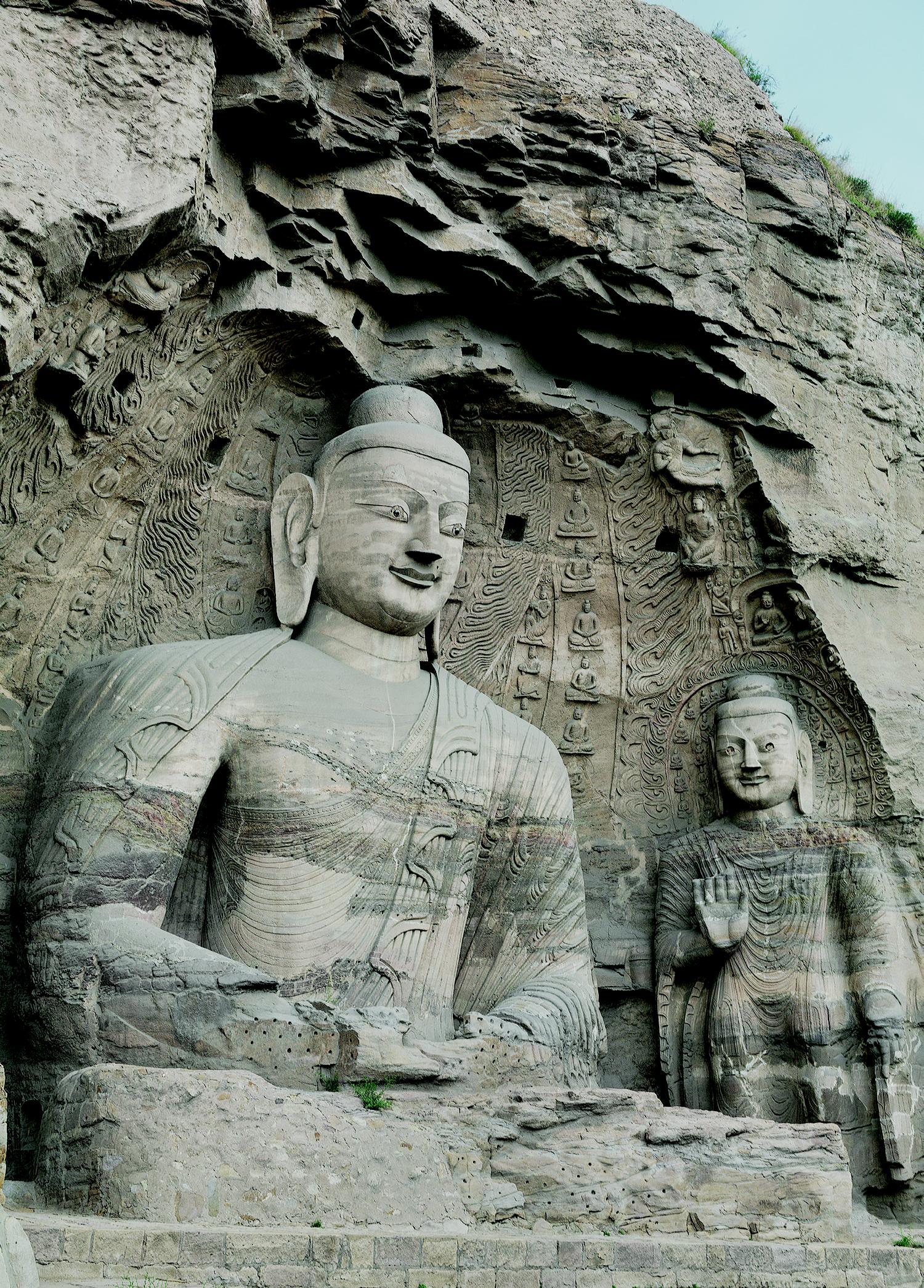 主佛内着僧祇支，边饰精致的联珠纹、忍冬纹带。外着袒右肩式佛衣，衣缘翻卷呈折带纹，具中亚犍陀罗艺术风格。双手结禅定印，拇指相对、竖起与余指搭成三角形。大佛与东立佛俱肩宽厚胸、臂膀壮实、挺拔健硕。